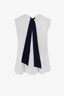 White sleeveless cotton blouse by s max mara with navy blue ribbon tied at the back neckline shown from behind