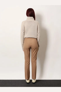A woman wears S Max Mara women’s Umanita cotton blend beige tailored trousers paired with a beige turtleneck sweater