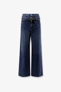 Sacai men’s blue denim jeans featuring dark blue high waist wide-leg pants with belt loop detail