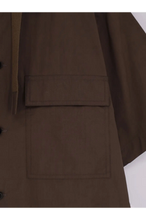 Sacai men’s cotton shirt beige styled with a brown utility jacket featuring flap pockets and subtle textured fabric