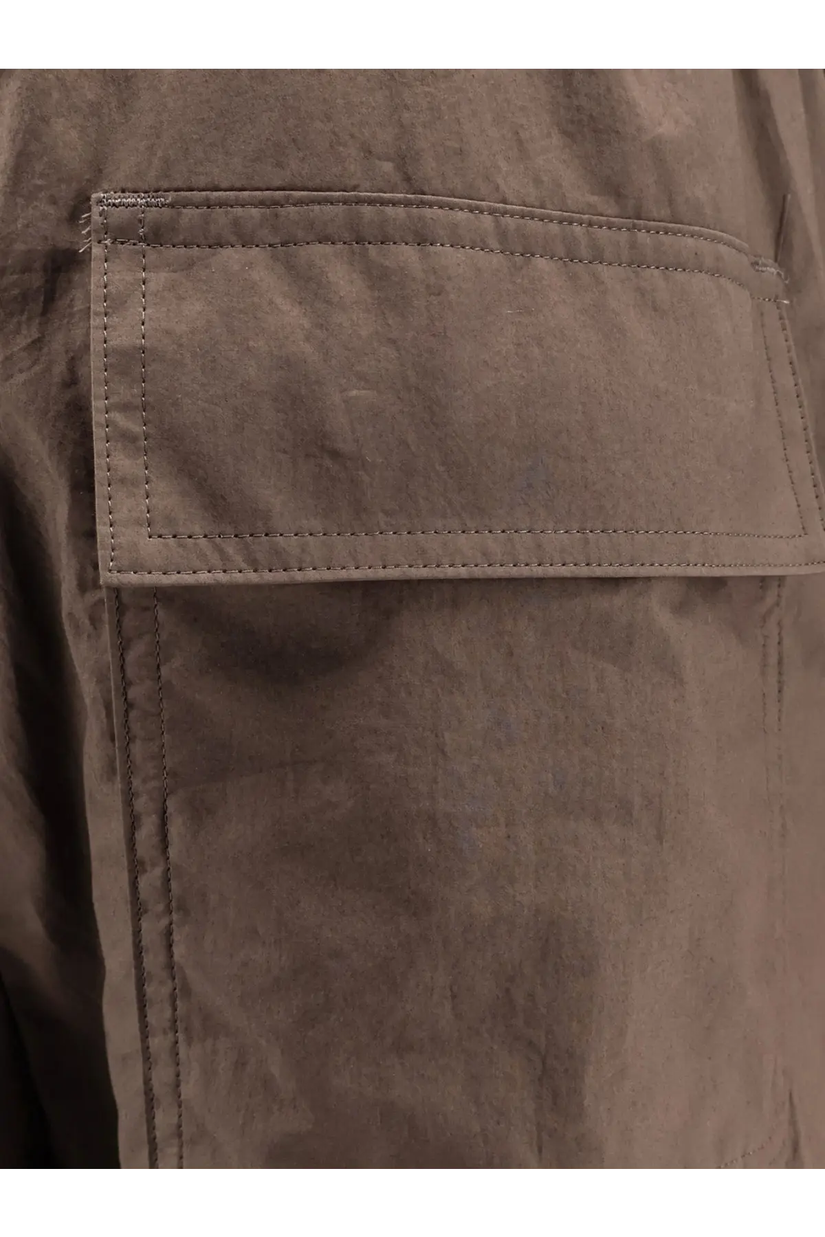 Sacai men’s cotton trousers beige featuring a muted brown canvas pocket with reinforced stitching and textured fabric