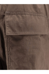 Sacai men’s cotton trousers beige featuring a muted brown canvas pocket with reinforced stitching and textured fabric