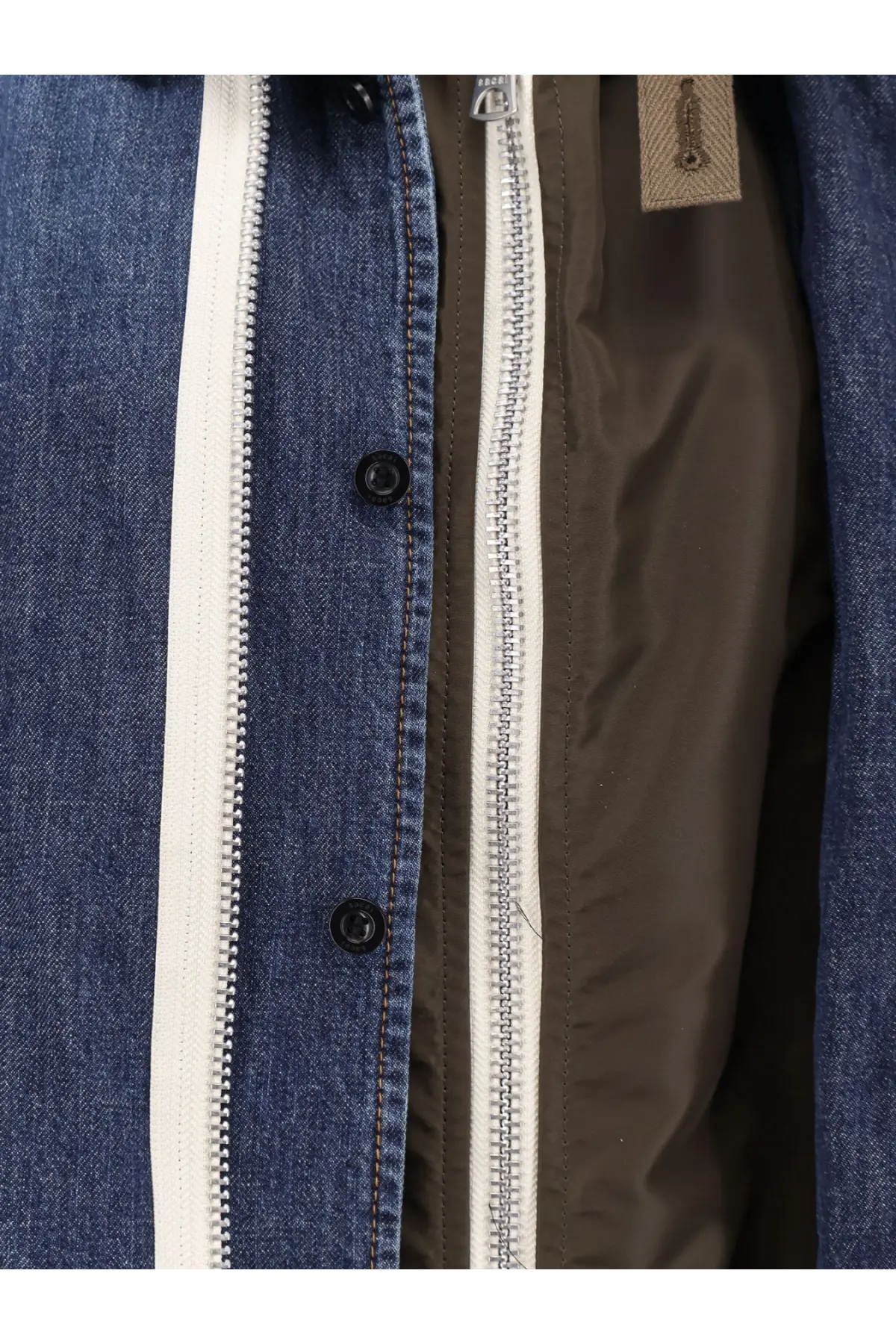 Sacai men’s blue denim jacket with white zipper and black buttons showcasing a stylish casual look