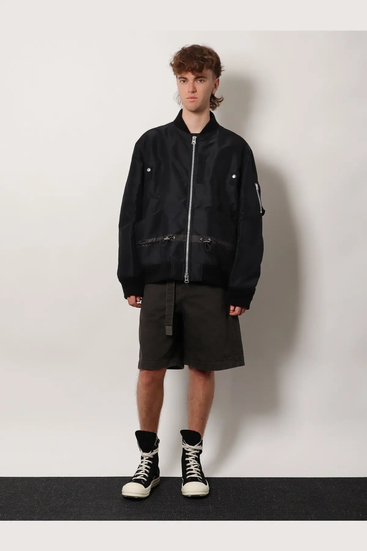 Sacai men’s black nylon bomber jacket with silver zipper and snap buttons detailing on the front