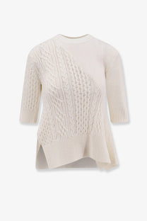 Sacai women’s cream-colored asymmetrical cotton blend sweater with diagonal cable knit and three-quarter sleeves