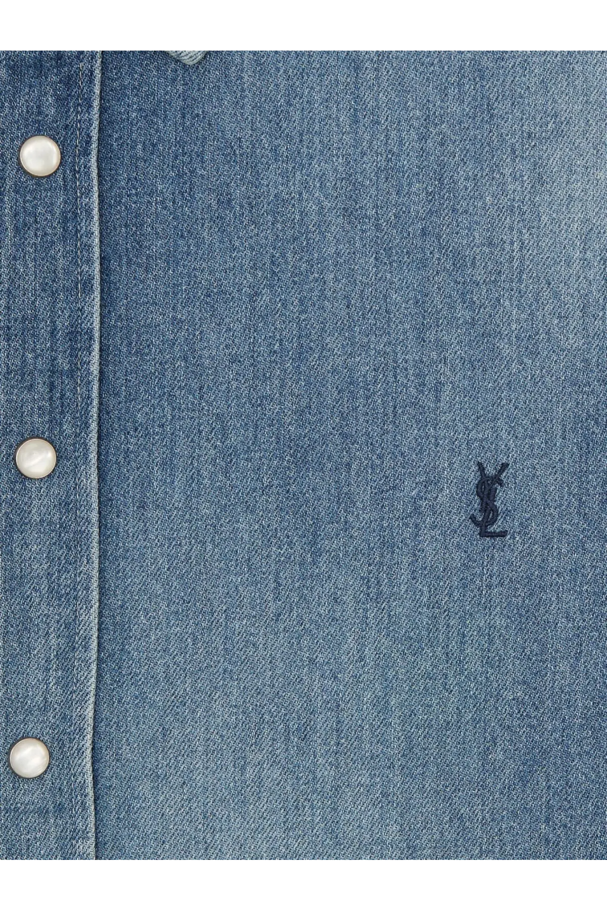 Saint Laurent men’s blue denim shirt with white buttons and small black embroidered YSL logo on the front
