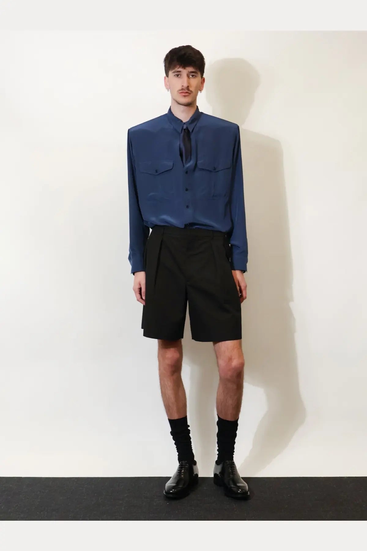 Saint laurent men’s certified cotton shorts black paired with a sleek navy blue satin button-up shirt with chest pockets