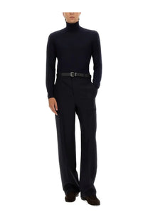 Black turtleneck sweater with long sleeves and high collar made of smooth knit fabric paired with saint laurent mens blue high waist pants
