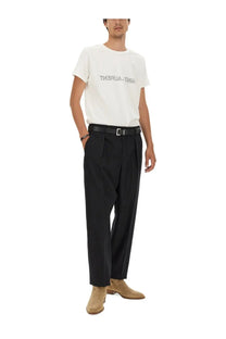 Black pleated trousers with a sleek tailored fit paired with saint laurent men’s inverted shirt white front view