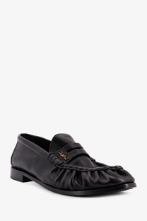 Saint Laurent men’s black leather loafer with ruffled toe and gold-tone YSL logo on the front