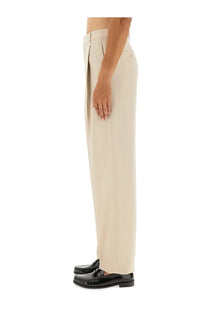 Saint Laurent men’s beige light wool pants with tailored fit pleated trousers and subtle side pockets