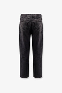 Saint Laurent men’s long Mick black denim trousers in black showing faded distressed back with classic pockets