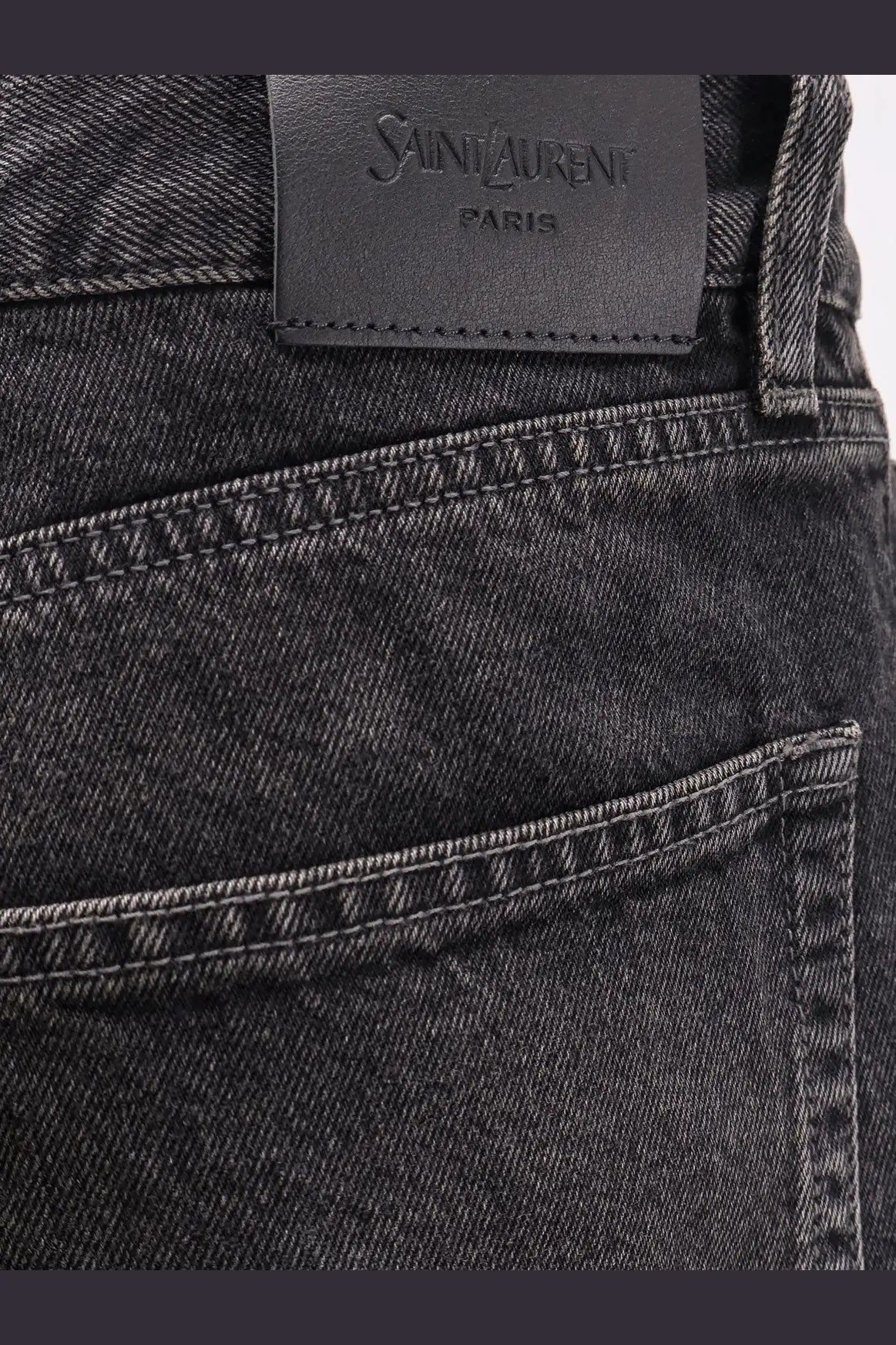 Saint Laurent men’s long mick black denim trousers with subtle faded wash white stitching and leather brand label