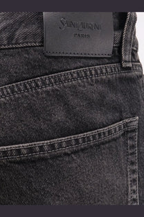 Saint Laurent men’s long mick black denim trousers with subtle faded wash white stitching and leather brand label