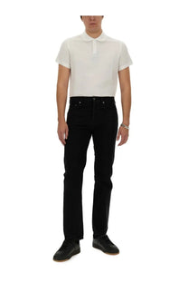 Black slim-fit denim jeans with classic five-pocket design and silver-toned hardware paired with Saint Laurent men’s monogram polo white
