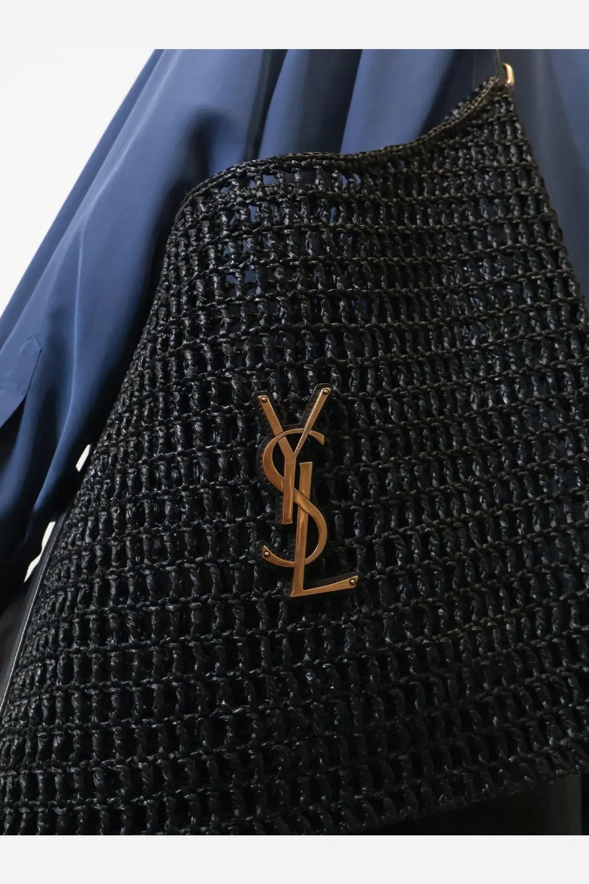 Saint Laurent men’s black raffia shoulder bag with woven straw texture and gold-tone YSL logo emblem on front