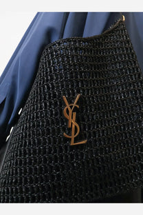 Saint Laurent men’s black raffia shoulder bag with woven straw texture and gold-tone YSL logo emblem on front