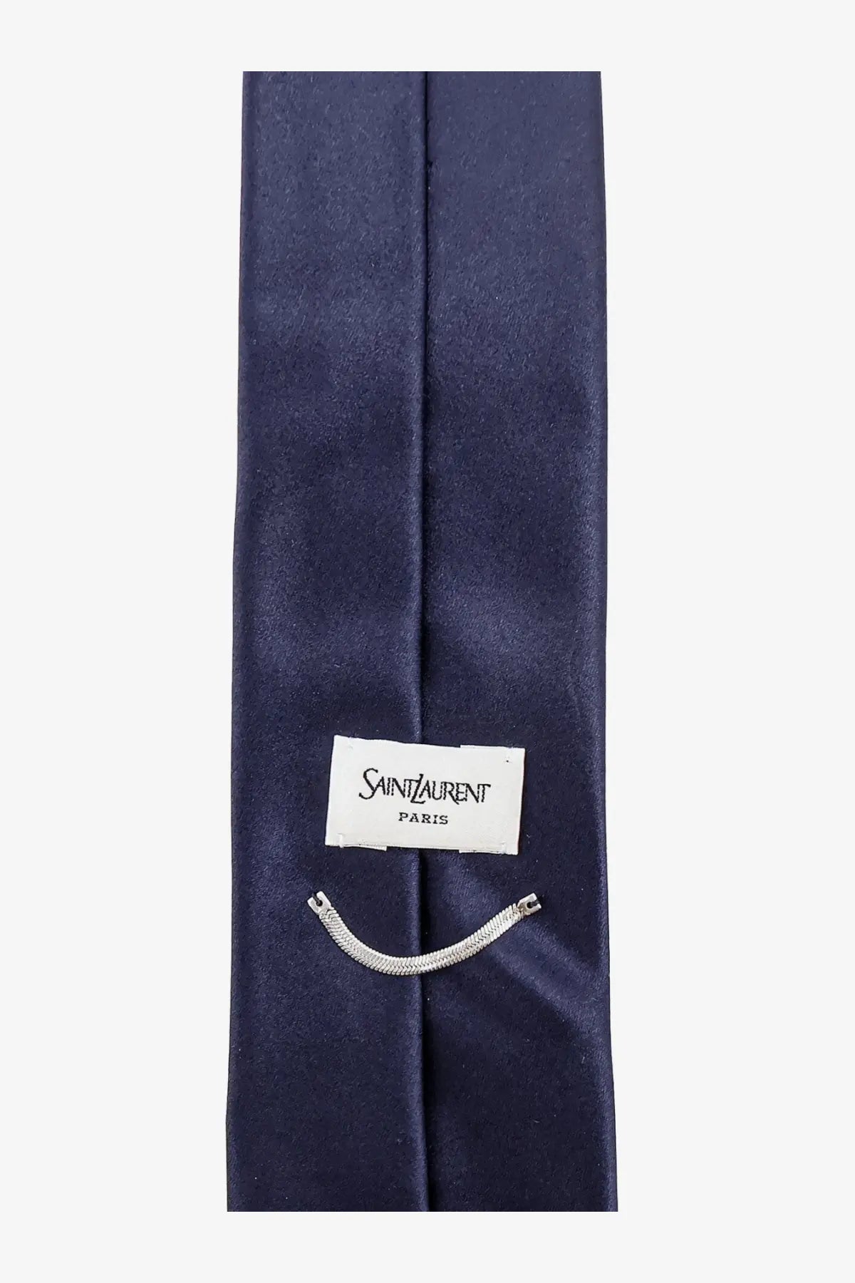 Saint Laurent men’s satin tie in navy blue with subtle sheen and white label featuring the brand name Paris