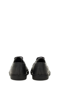 Saint Laurent men’s smooth black leather gym sneaker with lace-up design and subtle stitching details
