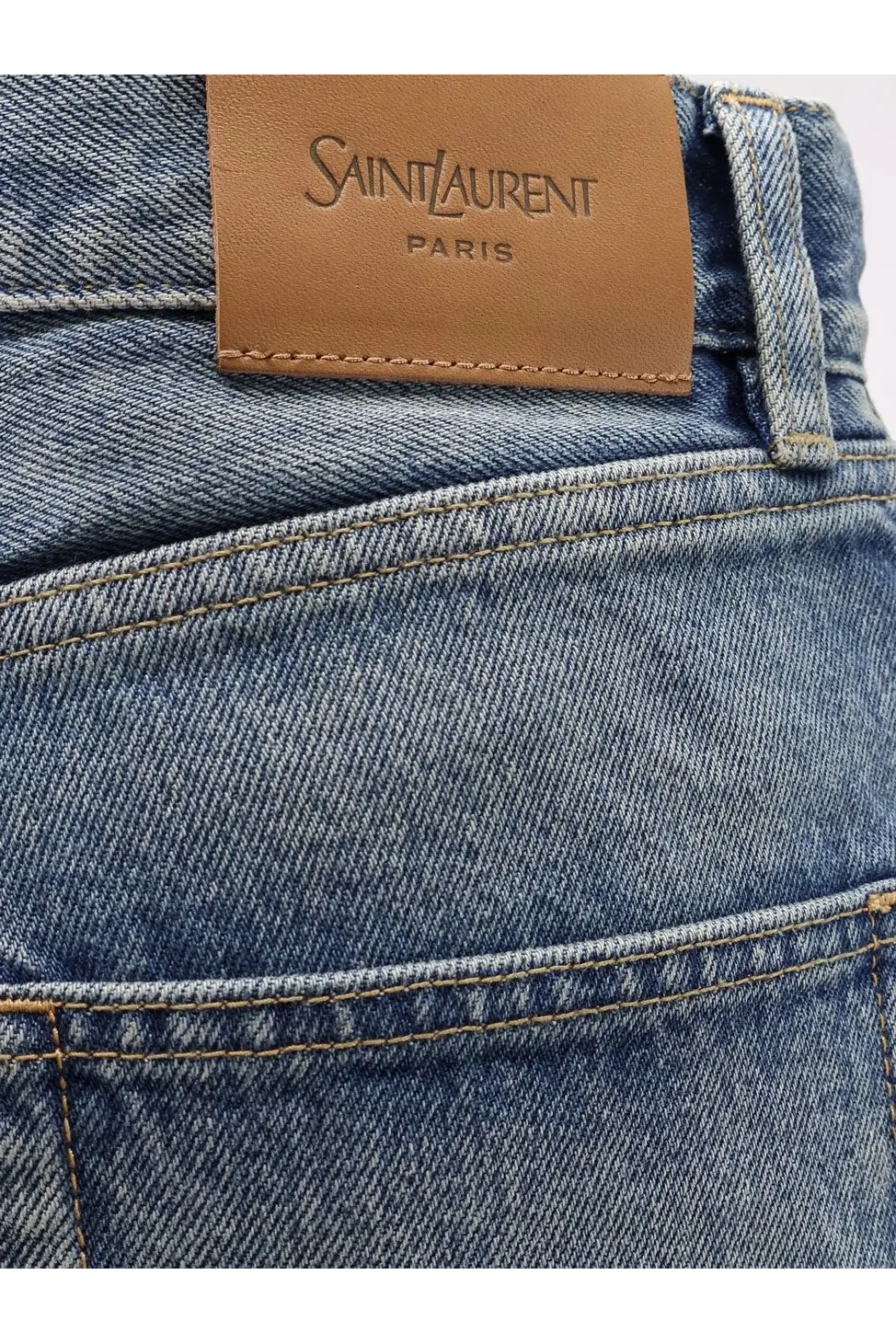 Saint Laurent women’s ankle midi blue denim jeans featuring a tan leather Saint Laurent Paris brand label on the back