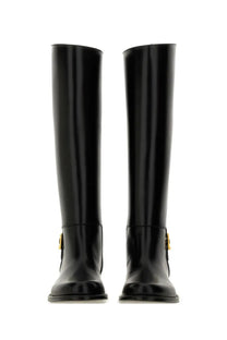 Saint Laurent women’s horny black knee-high boots in patent leather with gold-tone buckle accents
