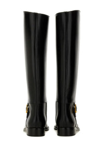 Saint Laurent women’s horny black knee-high boots in black patent leather with gold-tone buckle details