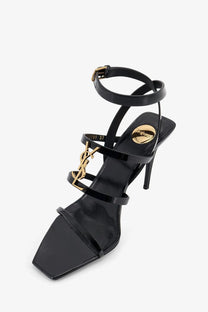 Saint Laurent women’s cassandre black patent leather sandals with strappy design and gold-tone YSL logo hardware
