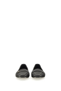 Saint Laurent women’s black leather loafers with subtle metallic logo on the vamp for elegant wear