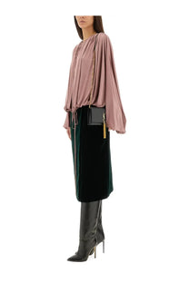 A sleek black ysl clutch with a gold-tone logo and tassel paired with a saint laurent women’s fluid knit blouse blue