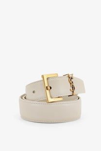 Saint Laurent women’s cream-colored leather belt with gold-tone rectangular buckle featuring ysl logo