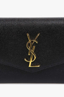 Saint Laurent women’s black leather crossbody bag with textured leather and prominent gold-tone ysl logo clutch style