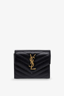 Saint Laurent women’s black leather quilted card case with gold-tone YSL logo for stylish wallet use