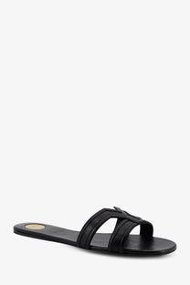 Saint Laurent women’s Mabrouka black leather slide sandal with minimalist design and small gold logo on the insole