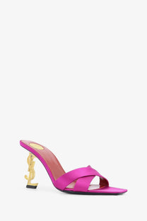 Saint Laurent women’s Opyum satin sandals in fuchsia with gold-tone YSL logo heel shown from the back side