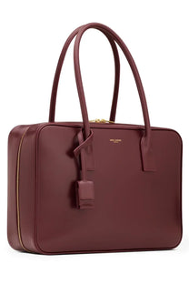 Saint Laurent women’s sac de jour bag in burgundy leather with gold-tone hardware and minimalist tote design
