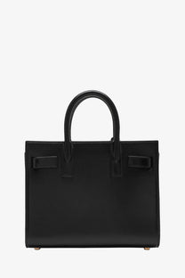 Black leather saint laurent small sac de jour bag with structured rectangular shape and top handles for women
