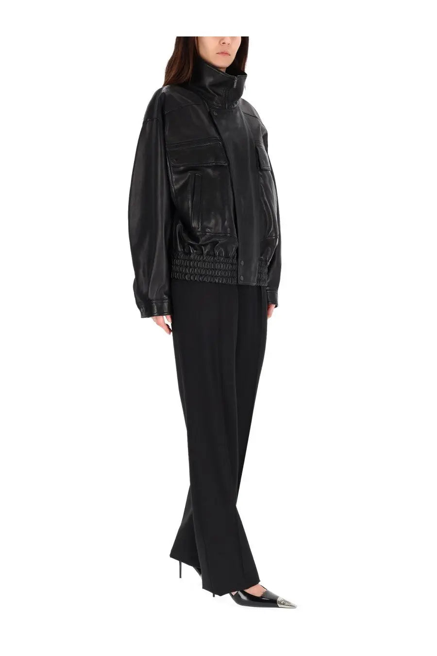 Black faux leather bomber jacket with high collar and front pockets paired with Saint Laurent tailored pants black