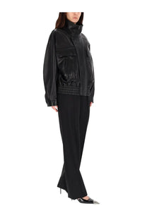 Black faux leather bomber jacket with high collar and front pockets paired with Saint Laurent tailored pants black
