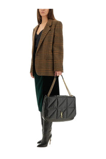 Black quilted leather saint Laurent handbag with gold chain strap and ysl logo plaque alongside green velvet midi skirt