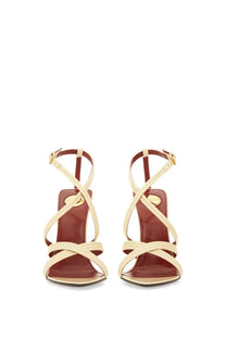 Saint Laurent women’s cream-colored leather wedge sandal with crisscross straps and gold-tone buckle in beige