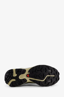 Back side of salomon men’s technical fabric trail running shoe in black and beige with rugged outsole and red logo