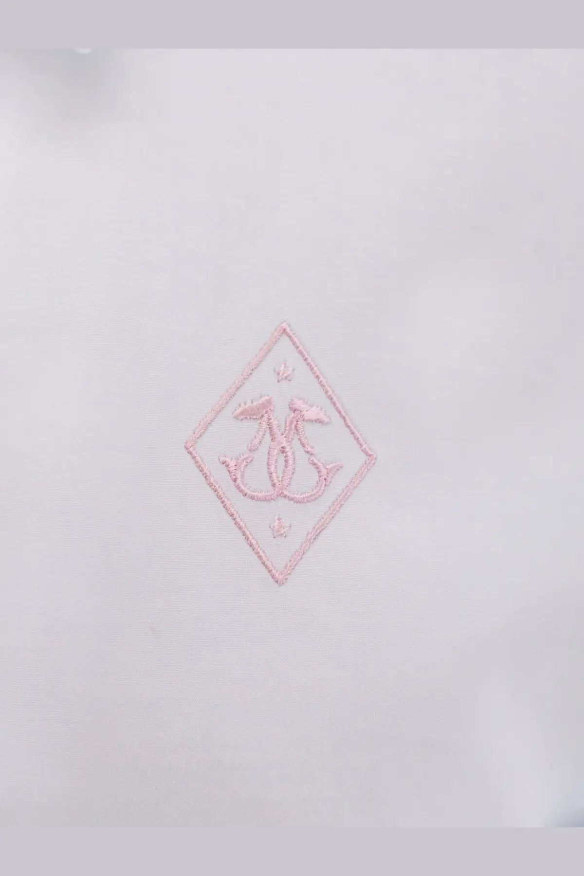 A delicate pink embroidered logo patch with interlocking initials on the seafarer women’s kim cotton shirt white