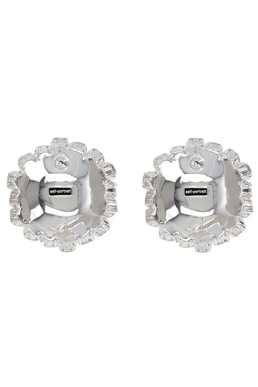 Silver flower-shaped stud earrings with faceted crystal border and central self-portrait brand tag