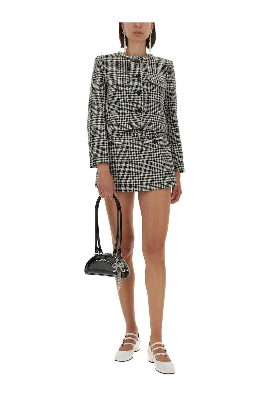 Black patent leather mini handbag with silver chain and bow detail paired with self-portrait multicolor houndstooth skirt pants