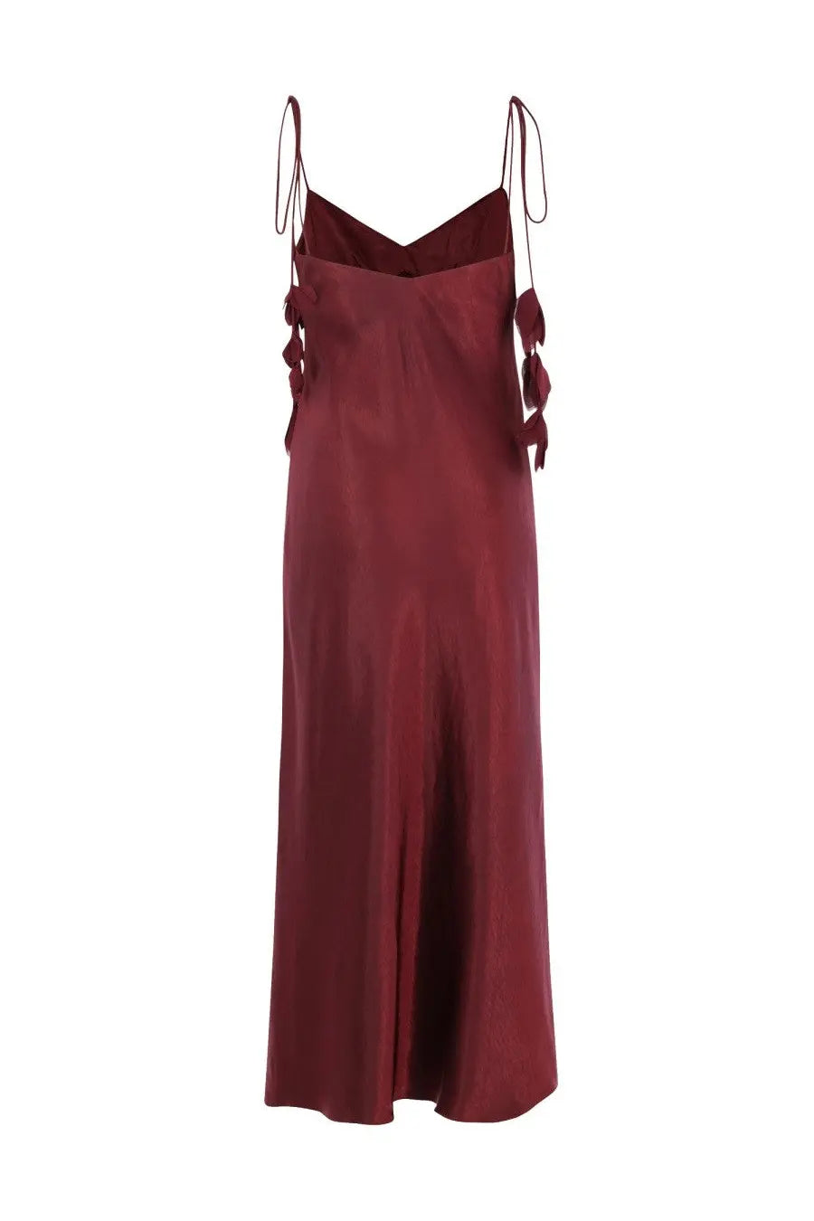 A flowing burgundy satin slip dress with delicate tied straps and decorative fabric tassels by Self-Portrait