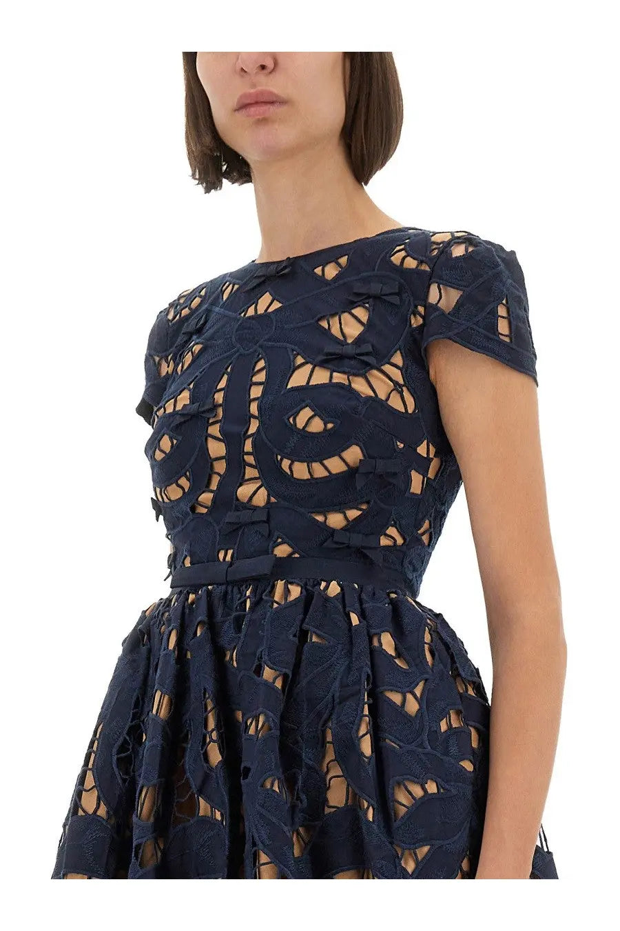 A navy blue lace mini dress by self portrait with intricate cut out patterns and a fitted bodice