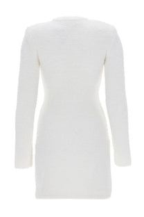 A sleek white long-sleeved ribbed knit mini dress by self-portrait with a fitted silhouette