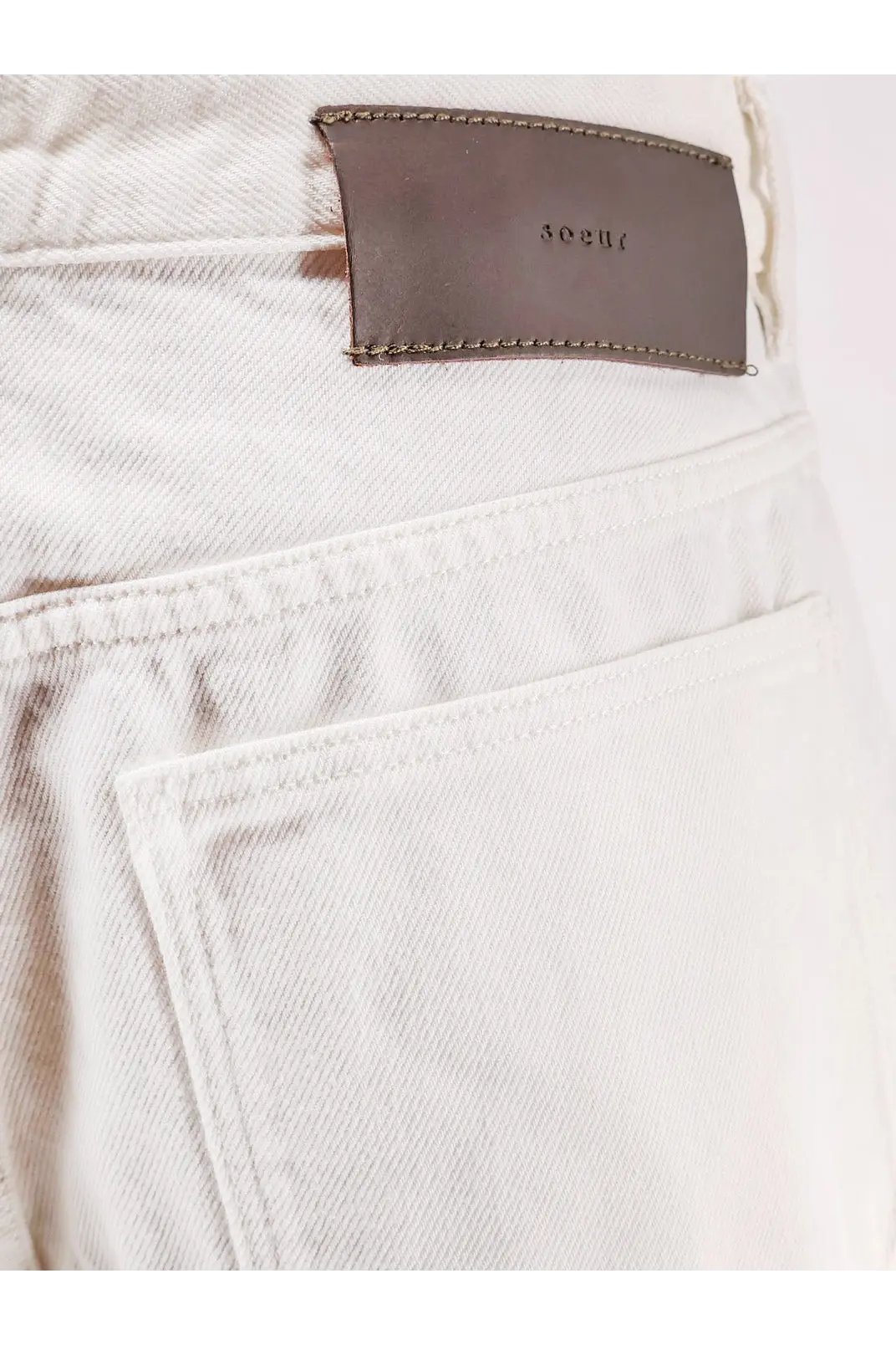 White denim jeans with a brown leather 302uc brand patch on the back from Soeur women’s Eliott denim trousers white