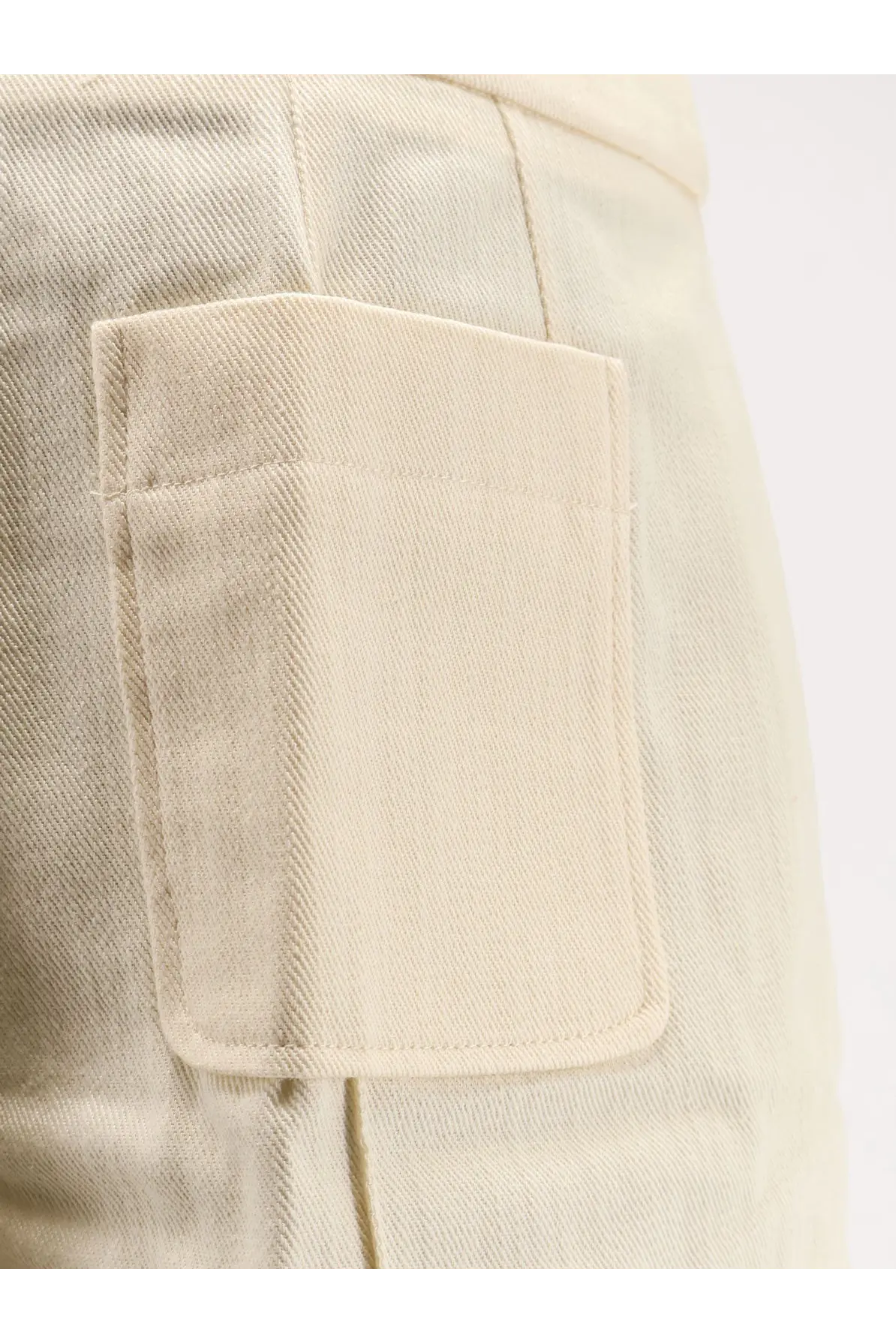 Close-up of beige denim pocket with neat stitching and subtle woven texture on soeur women’s hover cotton shorts crème back side