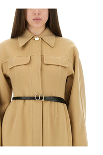 Black leather belt with gold tone u shaped buckle paired with sportmax women’s beige oil coat